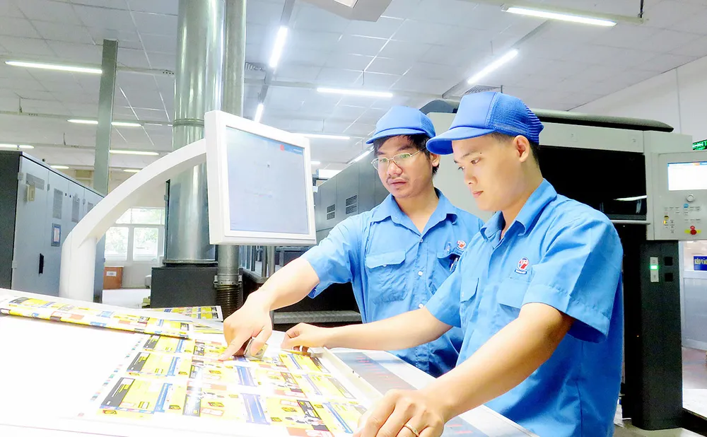 Được thông báo mức thưởng tết cao, công nhân Công ty In số 7 rất phấn khởi, an tâm làm việc trong những ngày cuối năm.    Ảnh: THÁI PHƯƠNG 