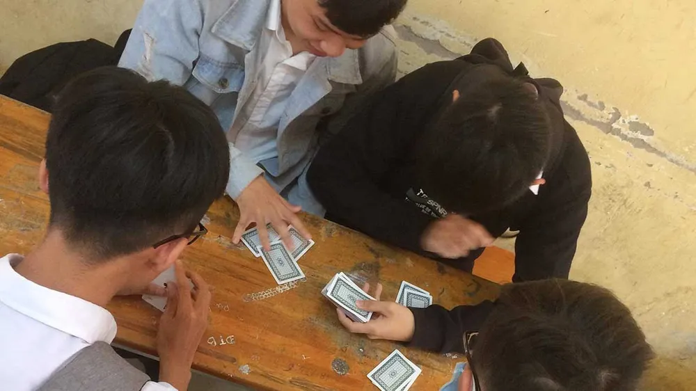 Ra tết, sau giờ học, học sinh một trường THPT ở TP Tân An, tỉnh Long An                                       ở lại lớp đánh bài giải khuây.                  Ảnh: LÊ DUY