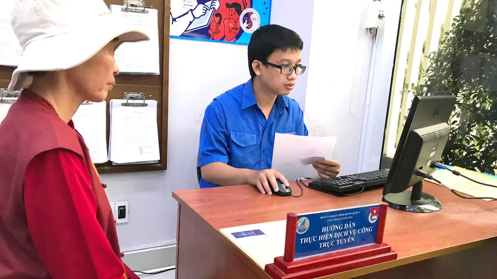 Công chức quận 4 tư vấn cho người dân nộp hồ sơ qua mạng.  Ảnh: VIỆT DŨNG