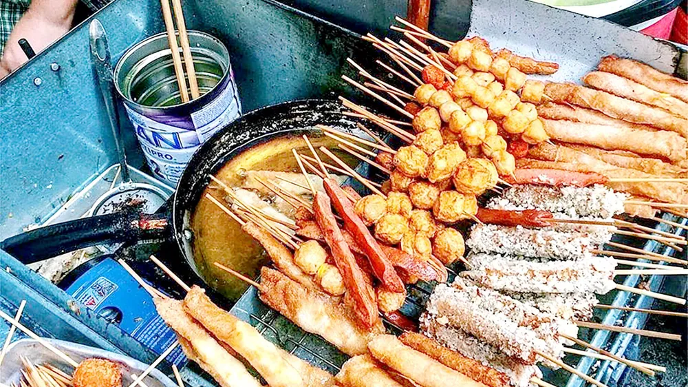 Những món quà vặt bắt mắt không rõ xuất xứ, thiếu an toàn  vệ sinh thực phẩm vẫn tràn lan trước cổng các trường học. Ảnh: THANH MAI