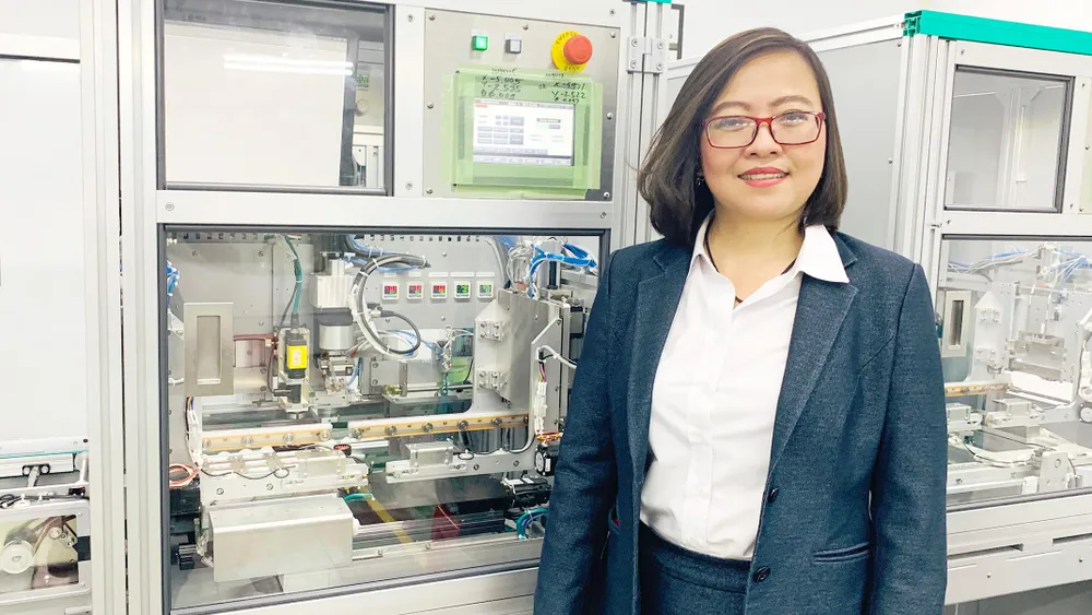 Chị Công Tằng Tôn Nữ Thùy Trang bên hệ thống dây chuyền  sản xuất các thiết bị đa năng tại Công ty ITO Việt Nam