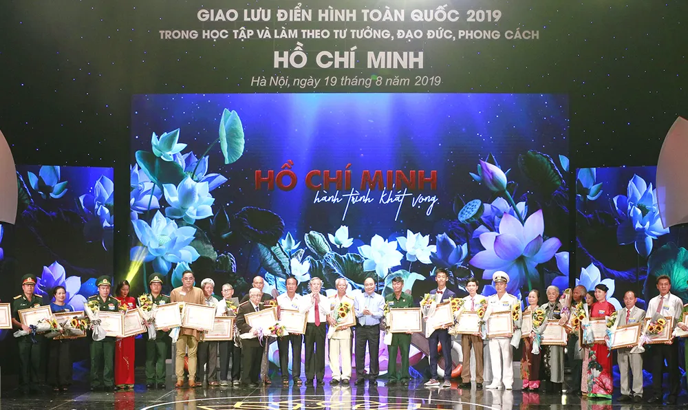 Thủ tướng Nguyễn Xuân Phúc trao bằng khen của Thủ tướng Chính phủ cho những cá nhân và  điển hình tiên tiến trong học tập và làm theo tấm gương đạo đức Hồ Chí Minh trong chương trình  giao lưu điển hình toàn quốc 2019.   Ảnh: TRẦN BÌNH