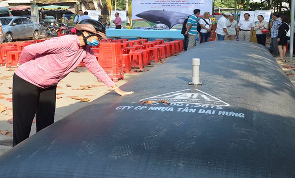 Người dân tham quan túi chứa nước ngọt do các doanh nghiệp  giới thiệu để ứng phó với xâm nhập mặn. Ảnh: HỮU HIỆP