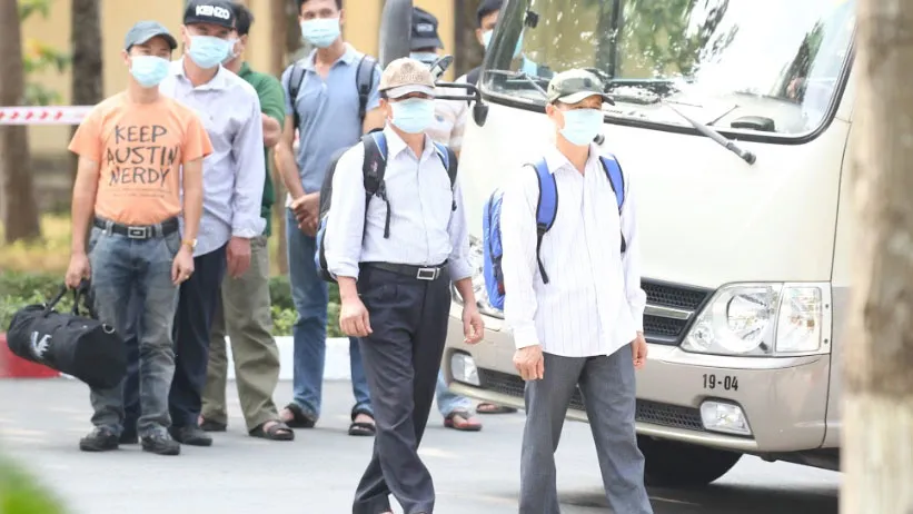 ​  Người dân đóng giả các công dân về Việt Nam từ vùng dịch được đưa về khu cách ly tại Sư đoàn 317 - Quân khu 7