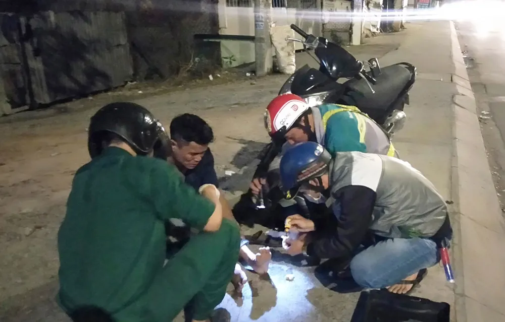 Các thành viên Đội cứu trợ giao thông quận 12 giúp đỡ người bị té xe dọc đường