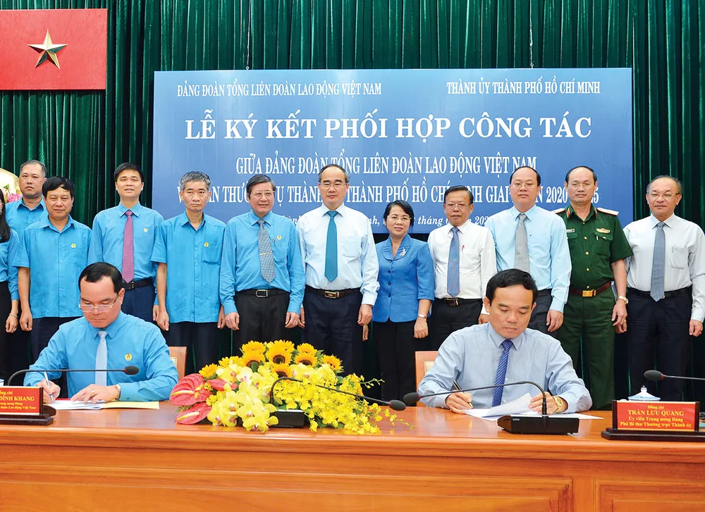 Bí thư Thành ủy TPHCM Nguyễn Thiện Nhân chứng kiến lễ ký kết  giữa Phó Bí thư Thường trực Thành ủy TPHCM Trần Lưu Quang và Chủ tịch Tổng Liên Đoàn Lao Động Việt Nam Nguyễn Đình Khang. Ảnh: VIỆT DŨNG
