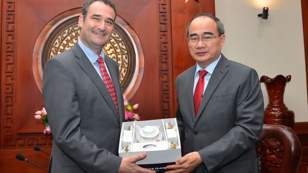 Bí thư Thành ủy TPHCM  Nguyễn Thiện Nhân tặng quà lưu niệm Tổng Lãnh sự Canada Kyle Nunas. Ảnh: VIỆT DŨNG