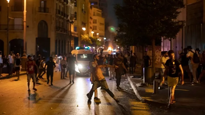 Người biểu tình ném đá về phía lực lượng an ninh tại Beirut. Ảnh: AP