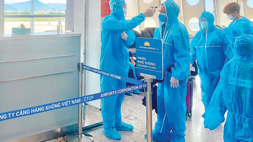 Kiểm tra thân nhiệt hành khách trước khi vào phòng chờ. Ảnh: HOÀNG HÙNG 