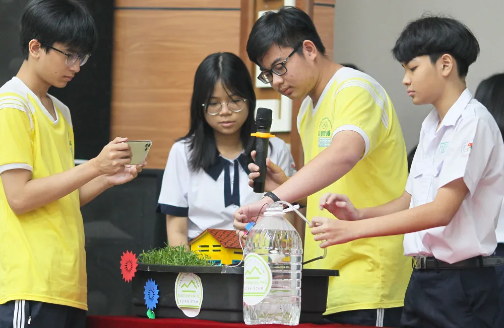 Các em giới thiệu hệ thống tưới tự động bằng cảm ứng đo độ ẩm  của đất.  Ảnh: HOÀNG HÙNG