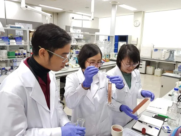 Nguyễn Trường Thịnh (bìa trái) trong áo blouse ở nơi làm việc.  Nguồn: vnuhcm.edu.vn