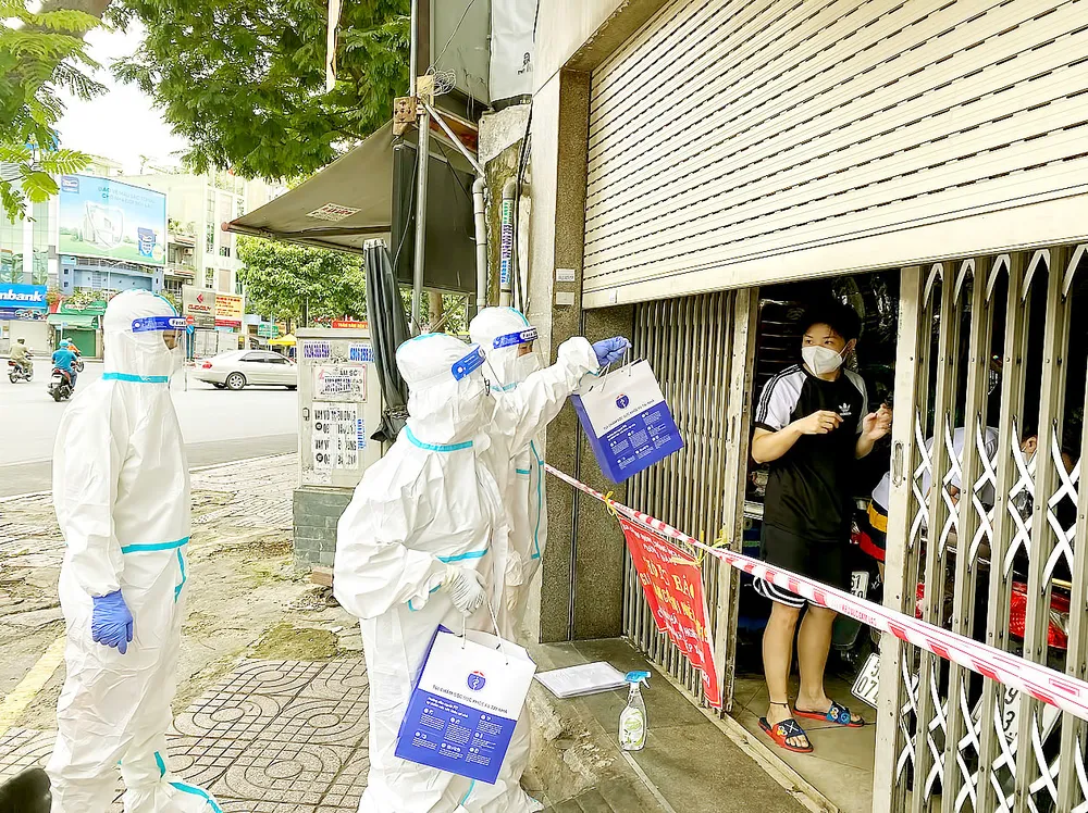 Phát thuốc điều trị Covid-19 cho người dân  đIều trị tại nhà ở quận 3, TPHCM. Ảnh: CAO THĂNG