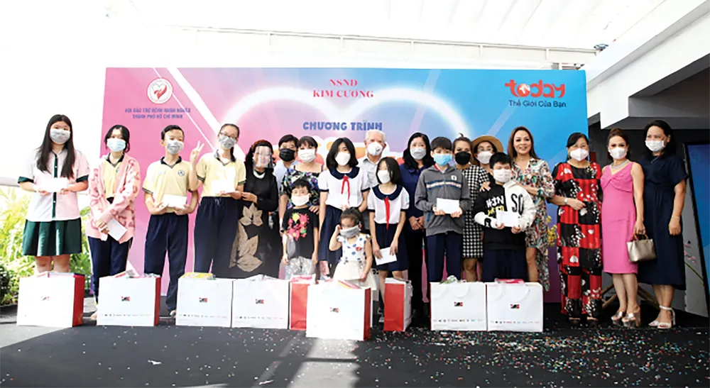 Tiến sĩ Trần Thành Long  và đại diện Tập đoàn IMC  gửi phần quà hỗ trợ cho các bé  ở khu vực quận 4, quận 6,  quận 8 và quận 12