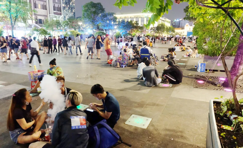 Người trẻ vô tư ngồi bệt ở phố đi bộ Nguyễn Huệ (quận 1) để ăn uống và xả rác