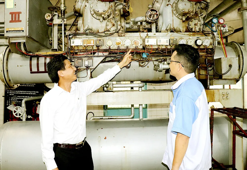 Anh Bùi Trọng Hữu trao đổi cùng công nhân trẻ  về sáng kiến anh đã thực hiện.  Ảnh: THÁI PHƯƠNG