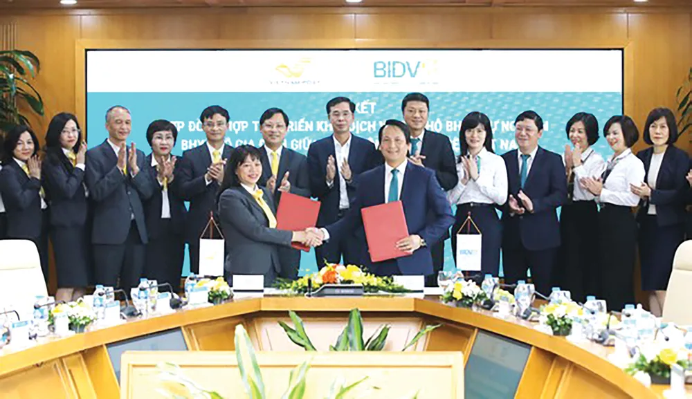 Ông Trần Long, Phó Tổng Giám đốc BIDV và bà Chu Thị Lan Hương,  Phó Tổng Giám đốc Vietnam Post, đại diện hai bên ký kết hợp đồng