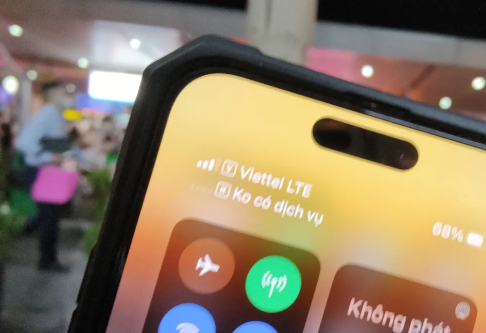 Tại sân bay Tân Sơn Nhất, nhiều người vừa xuống máy bay nháo nhào vì điện thoại không liên lạc được. Trên màn hình thiết bị, cột sóng di động của người dùng mạng MobiFone thông báo “không có dịch vụ”. Ảnh: BÁ TÂN