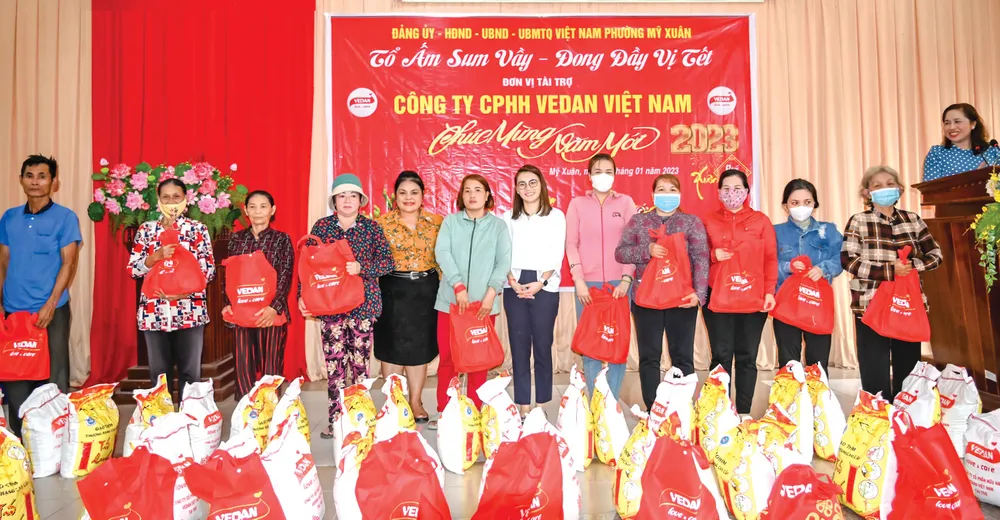 Bà Yang Nai Hsuan - Trợ lý đặc biệt Văn phòng Tổng Giám đốc Vedan Việt Nam (áo trắng) trao các phần quà Tết cho người dân tại xã Mỹ Xuân, Đồng Nai