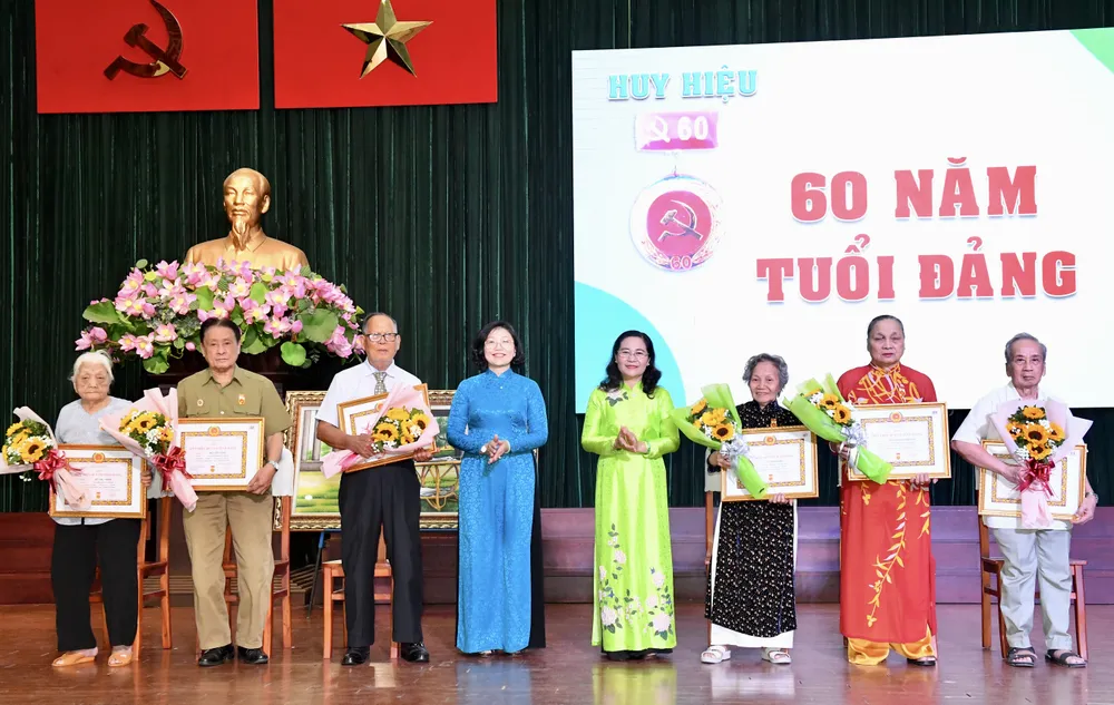 Chủ tịch HĐND TPHCM Nguyễn Thị Lệ và Bí thư Quận ủy quận 5 Huỳnh Ngọc Nữ Phương Hồng chúc mừng các đồng chí nhận Huy hiệu 60 năm tuổi Đảng. Ảnh: VIỆT DŨNG