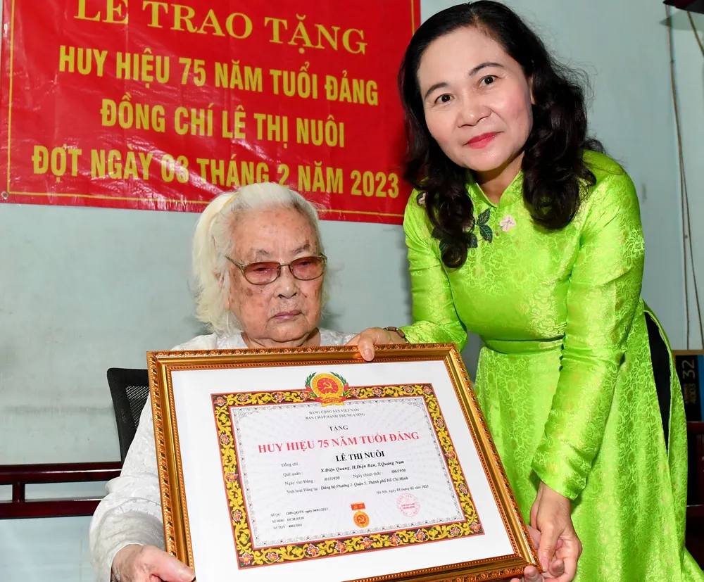 Chủ tịch HĐND TPHCM Nguyễn Thị Lệ trao Huy hiệu 75 năm tuổi Đảng cho đồng chí Lê Thị Nuôi. Ảnh: VIỆT DŨNG