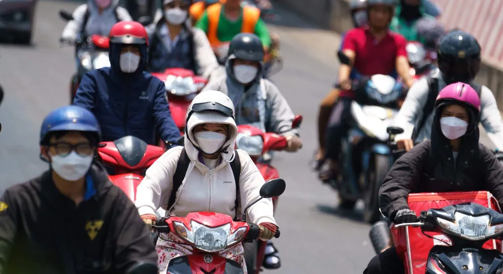 Người dân TPHCM mặc áo khoác khi ra đường vào ban ngày để tránh nắng nóng gay gắt. Ảnh: HOÀNG HÙNG