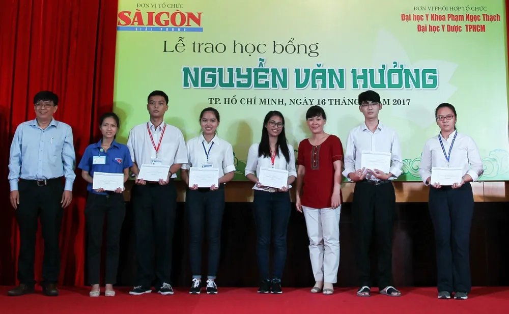 Bác sĩ Cao Xuân Minh (bìa trái) trao học bổng Nguyễn Văn Hưởng cho lứa sinh viên đầu tiên nhận học bổng toàn phần