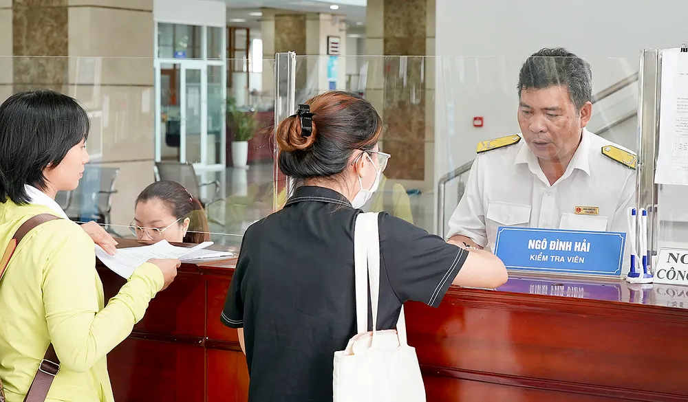 Hướng dẫn người dân, doanh nghiệp làm thủ tục khai báo thuế tại Cục Thuế TPHCM. Ảnh: HOÀNG HÙNG