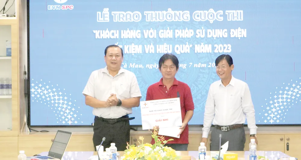 Đại diện chính quyền địa phương và Công ty Cà Mau trao giải nhì cho khách hàng