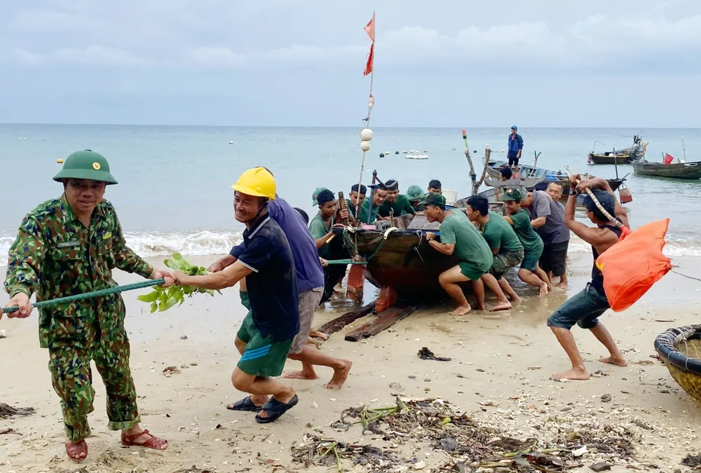 Lực lượng vũ trang hỗ trợ người dân đưa phương tiện vào bờ để tránh áp thấp nhiệt đới