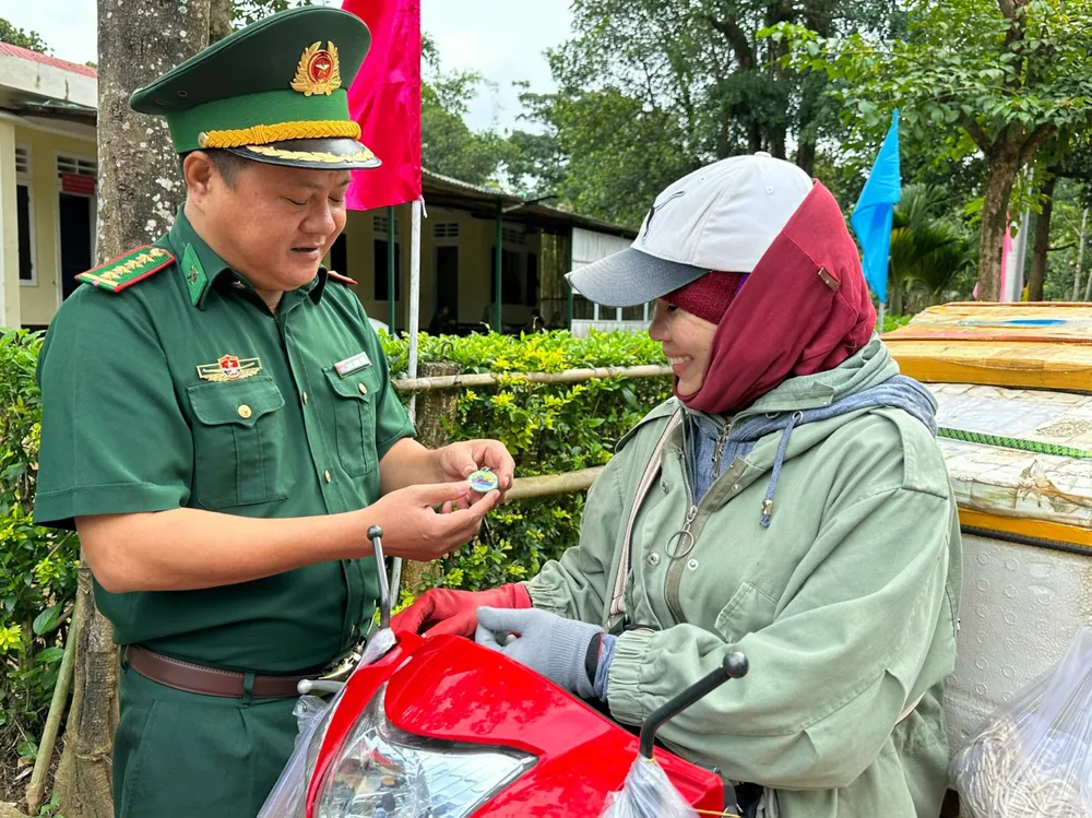 Cán bộ, chiến sĩ Đồn Biên phòng Hướng Lập tặng “móc khóa đường dây nóng” đến người dân ở khu vực biên giới Việt - Lào