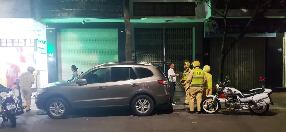 Một lái xe ô tô vi phạm nồng độ cồn trên 0,4mg/lít khí thở liên tục đối phó, câu giờ không hợp tác với tổ tuần tra trên đường Ỷ Lan (TP Quy Nhơn, Bình Định) vào đêm 9-10. Ảnh: NGỌC OAI