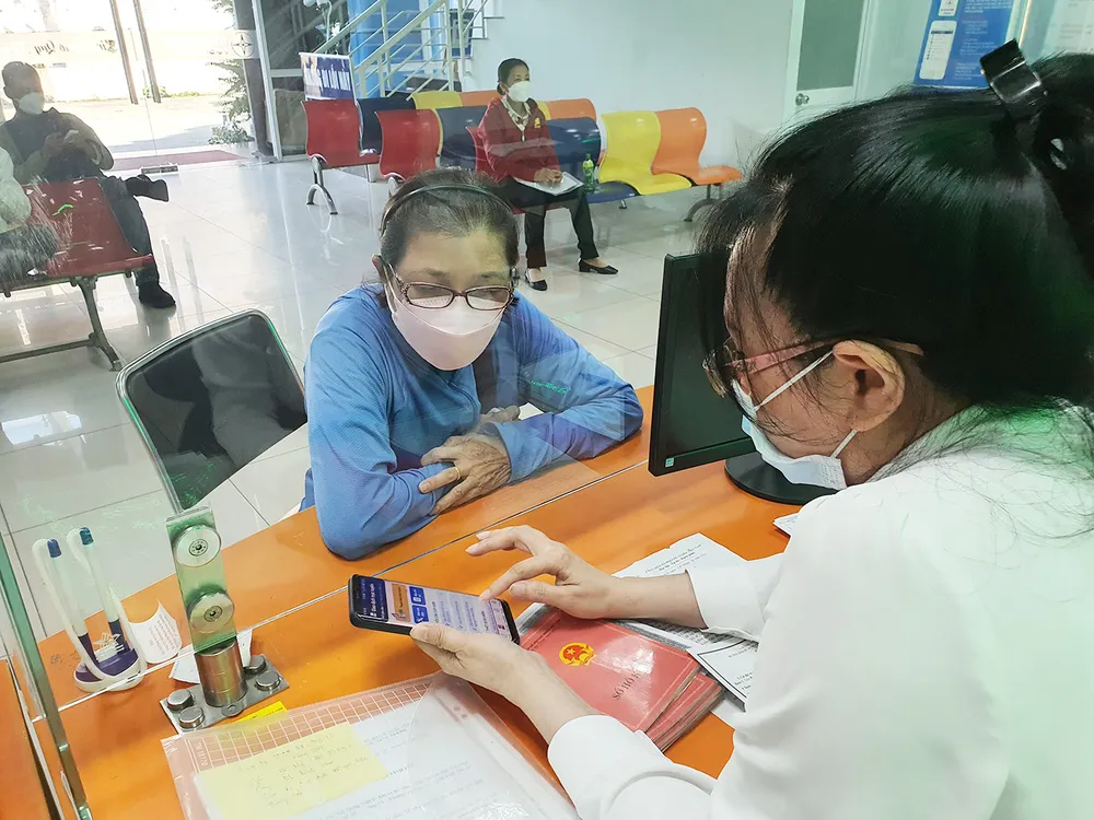 Nhân viên điện lực EVNHCMC hướng dẫn khách hàng cài đặt app để thuận tiện theo dõi lượng điện tiêu thụ của gia đình