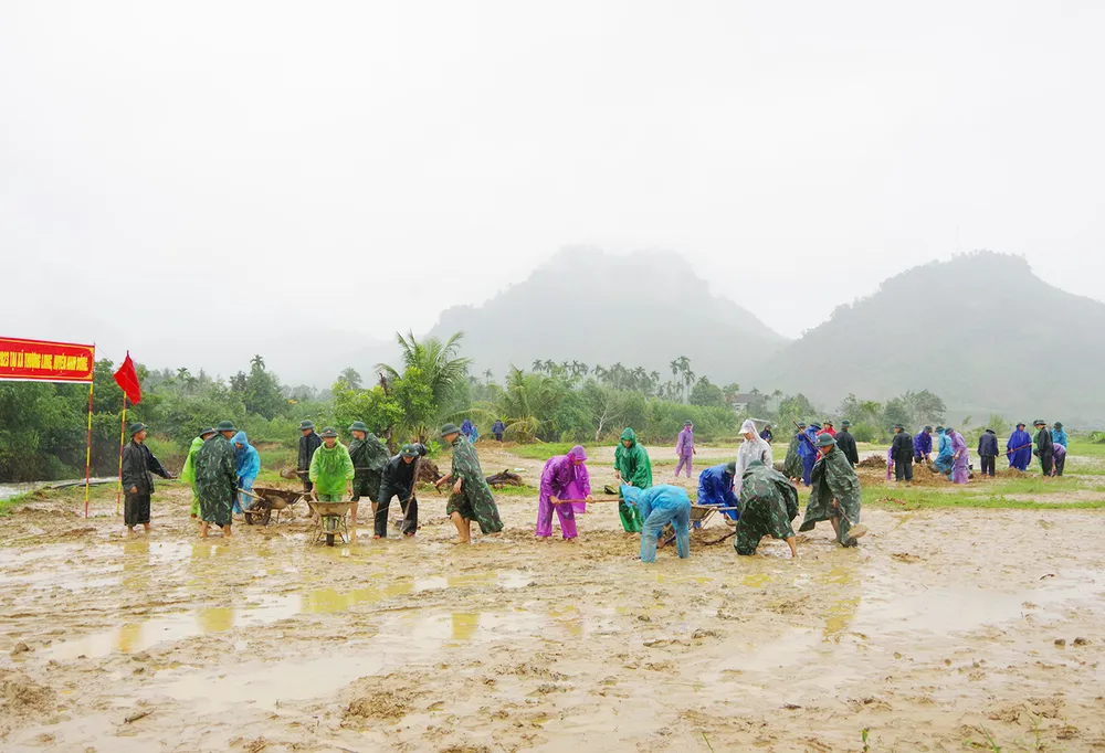 Giúp dân thu dọn đất sỏi trên đồng ruộng