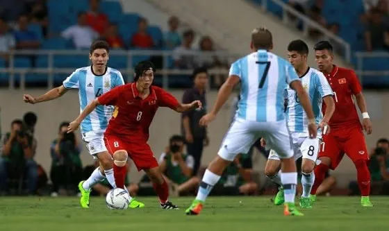 Tuấn Anh trong vòng vây của các cầu thủ Argentina