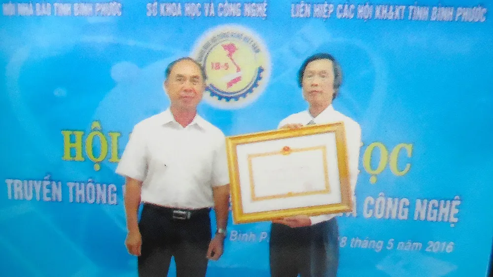 Ông Trần Văn Vân (phải) nhận Huân chương Lao động hạng hai tặng thưởng Sở KH-CN tỉnh Bình Phước