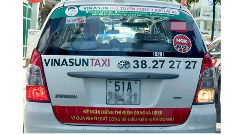 Nhiều xe taxi Vinasun ở TPHCM dán biểu ngữ phản đối Uber và Grab  ảnh 1