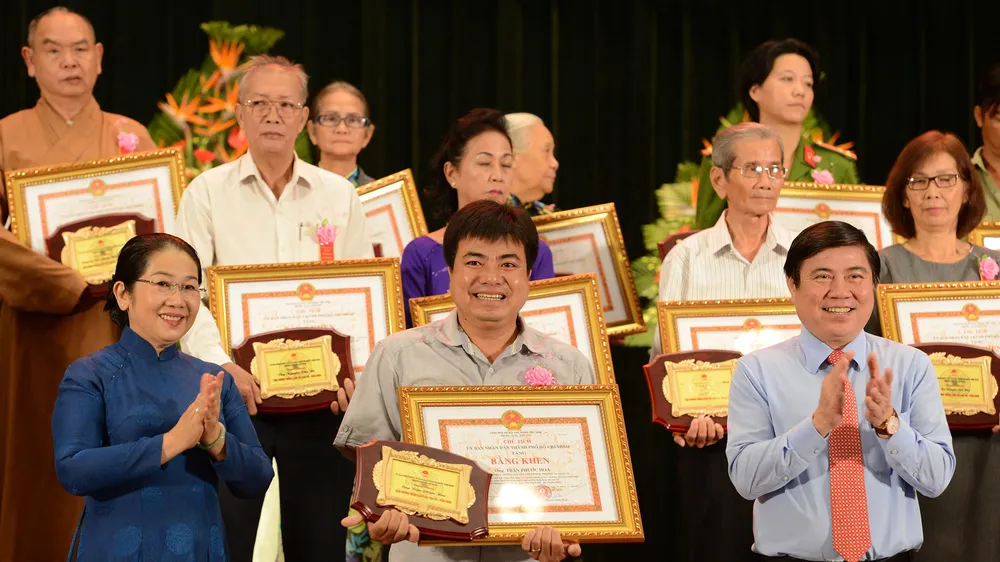 Chủ tịch UBND TPHCM Nguyễn Thành Phong và Phó Bí thư Thành ủy TPHCM Võ Thị Dung chúc mừng các tấm gương thầm lặng mà cao cả. Ảnh: VIỆT DŨNG