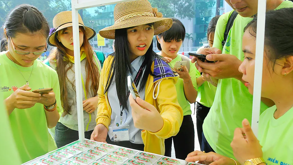 Người dân nhận diện sản phẩm doanh nghiệp xanh qua điện thoại. Ảnh: CAO THĂNG