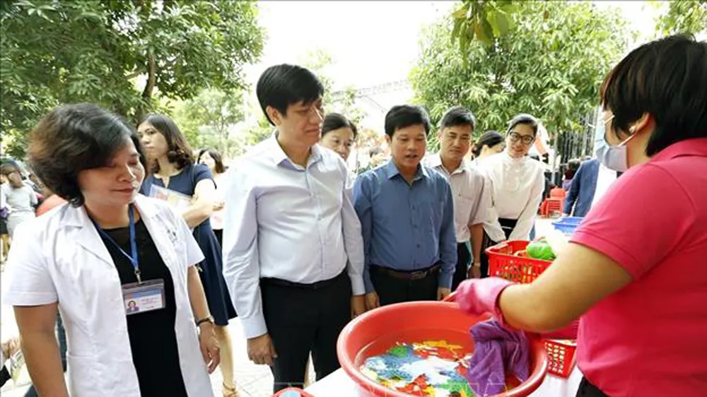 Các đại biểu tham quan thực hành rửa tay bằng xà phòng cho trẻ, vệ sinh đồ dùng giảng dạy và đồ chơi của trẻ tại trường mầm non Dịch Vọng Hậu, quận Cầu Giấy) ngay sau lễ triển khai chiến dịch phòng chống dịch bệnh