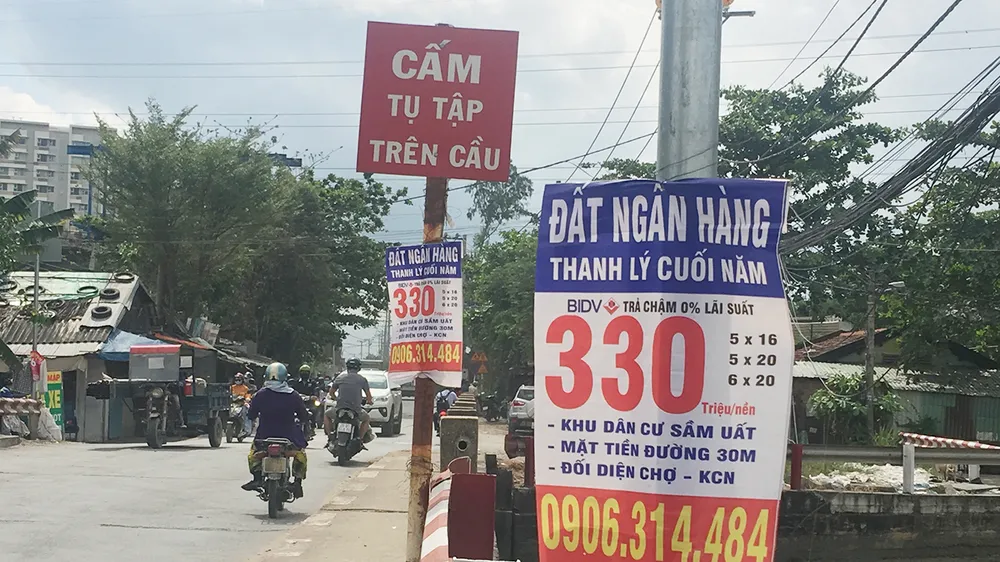 Bảng quảng cáo ngân hàng thanh lý nền đất giá rẻ treo dày trên đường Đỗ Xuân Hợp (quận 9, TPHCM)