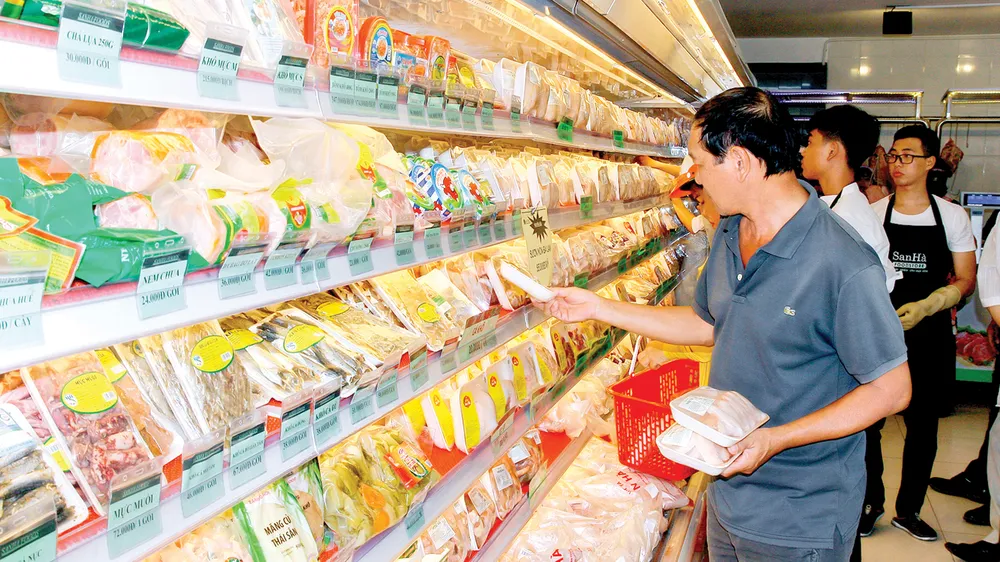 Khách hàng chọn mua các loại thịt gia cầm bình ổn tại cửa hàng San Hà Foodstore. Ảnh: TƯỜNG DÂN