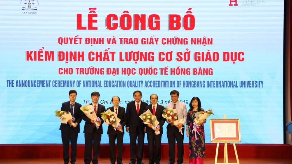 NGND.PGS.TS Hồ Thanh Phong – Hiệu trưởng ĐH HIU (giữa) tặng hoa cảm ơn đại diện Cục Quản lý chất lượng, TT KĐCLGD, Tập đoàn Giáo dục Nguyễn Hoàng đến tham dự sự kiện