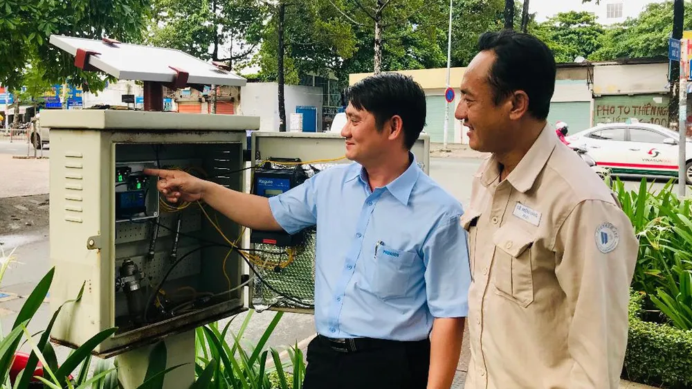 Anh Phan Trường Phát (trái) hướng dẫn đồng nghiệp  cách vận hành tủ năng lượng mặt trời