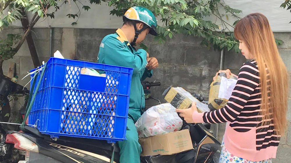 Khách nhận hàng từ đại diện  một công ty dịch vụ chuyển phát nhanh