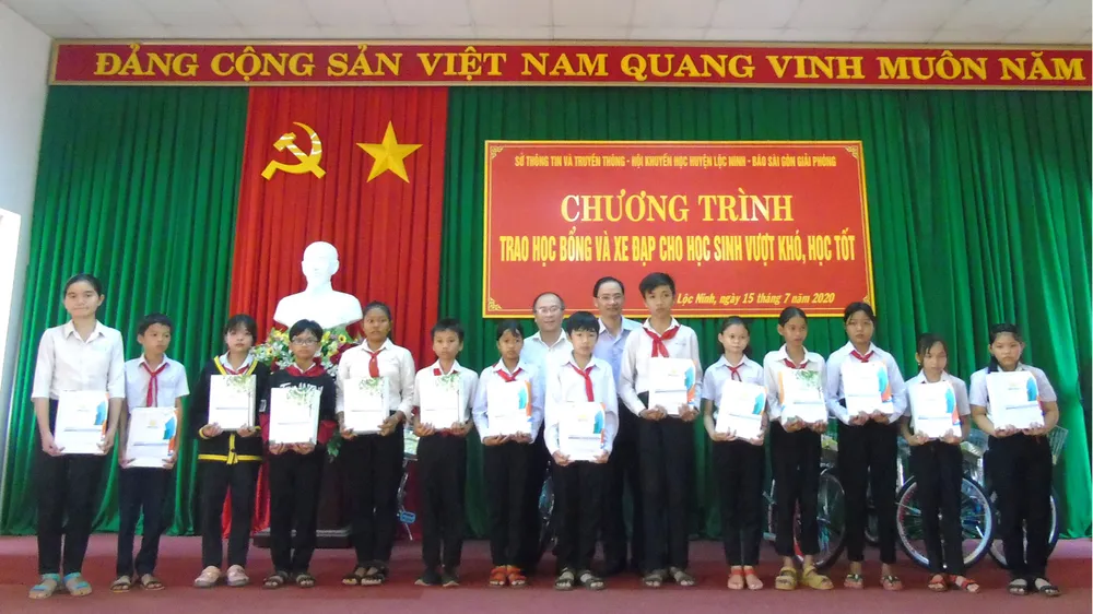 Các em học sinh nghèo Lộc Ninh nhận học bổng và quà tặng  của chương trình