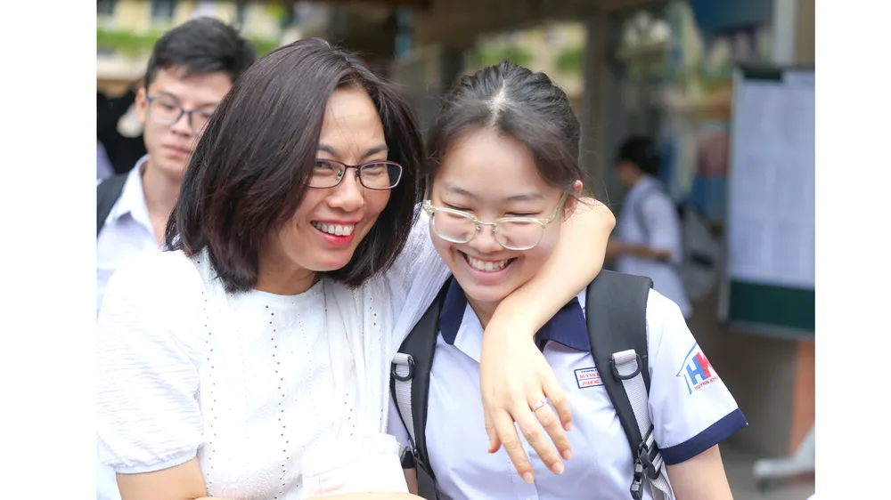 Các thí sinh vui mừng cùng phụ huynh sau khi thi môn Văn  tuyển sinh lớp 10 năm học 2020, tại điểm thi Trường THCS Minh Đức. Ảnh: HOÀNG HÙNG