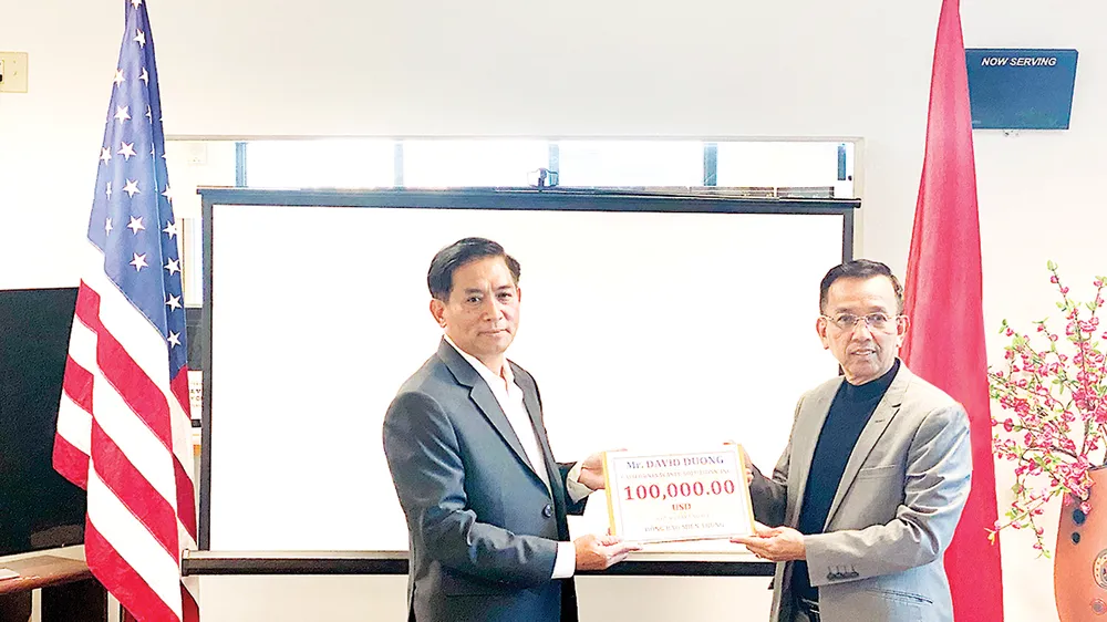 Ông David Dương, Chủ tịch Công ty CWS và VWS (bên phải) trao tặng tiền  để hỗ trợ bà con miền Trung đang gặp khó khăn trong mùa bão lũ