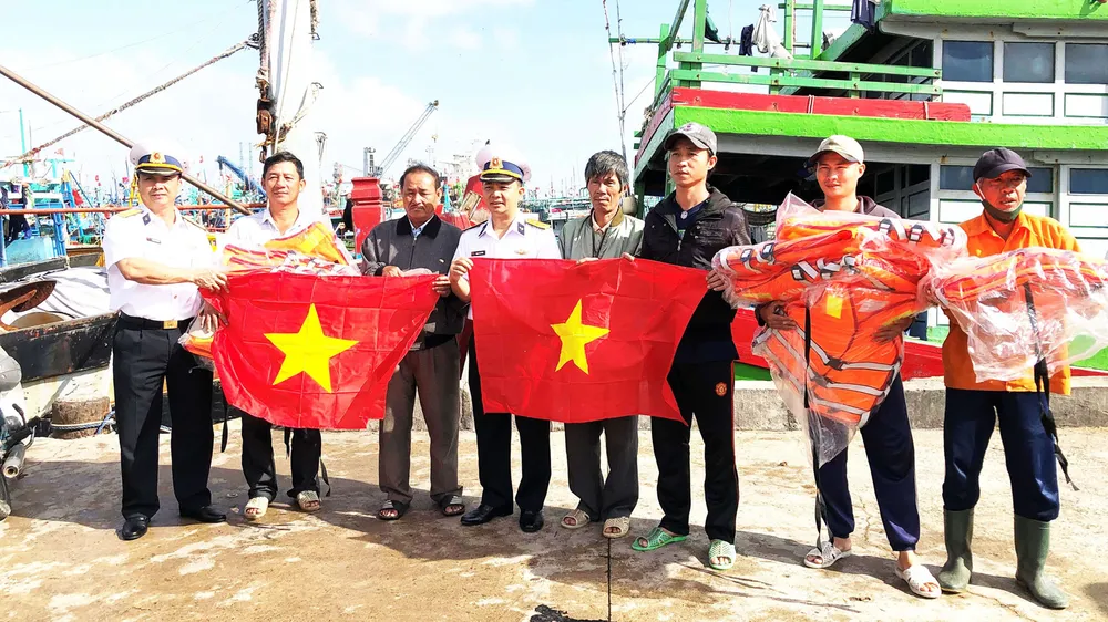 Vùng 4 Hải quân tặng cờ tổ quốc cho ngư dân Bình Định. Ảnh: NGỌC OAI