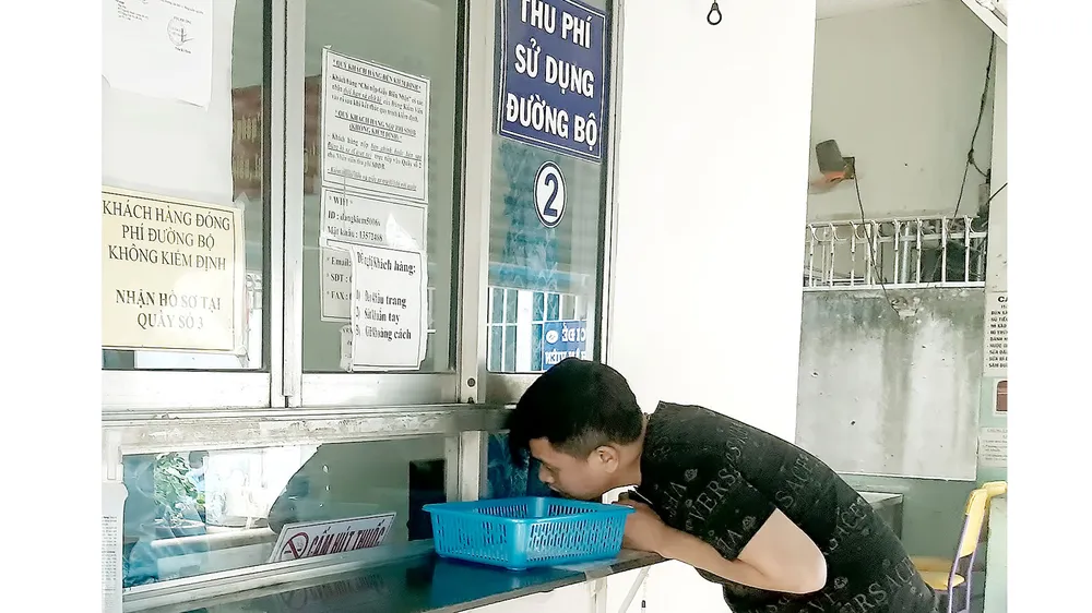 Đăng ký dịch vụ thu phí tự động không dừng  tại Trung tâm Đăng kiểm 50-06V, quận 7, TPHCM. Ảnh: ĐỨC TRUNG