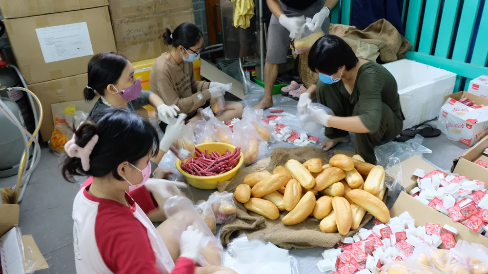 Nhóm anh Hoàng Đức Huy chuẩn bị các phần bánh mì để trao tặng
